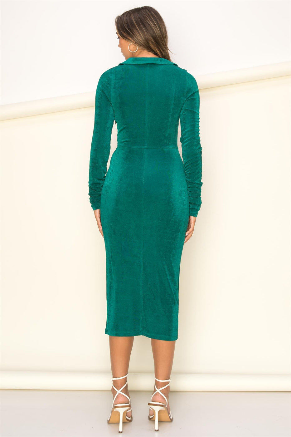 a woman in a green dress standing on a skateboard