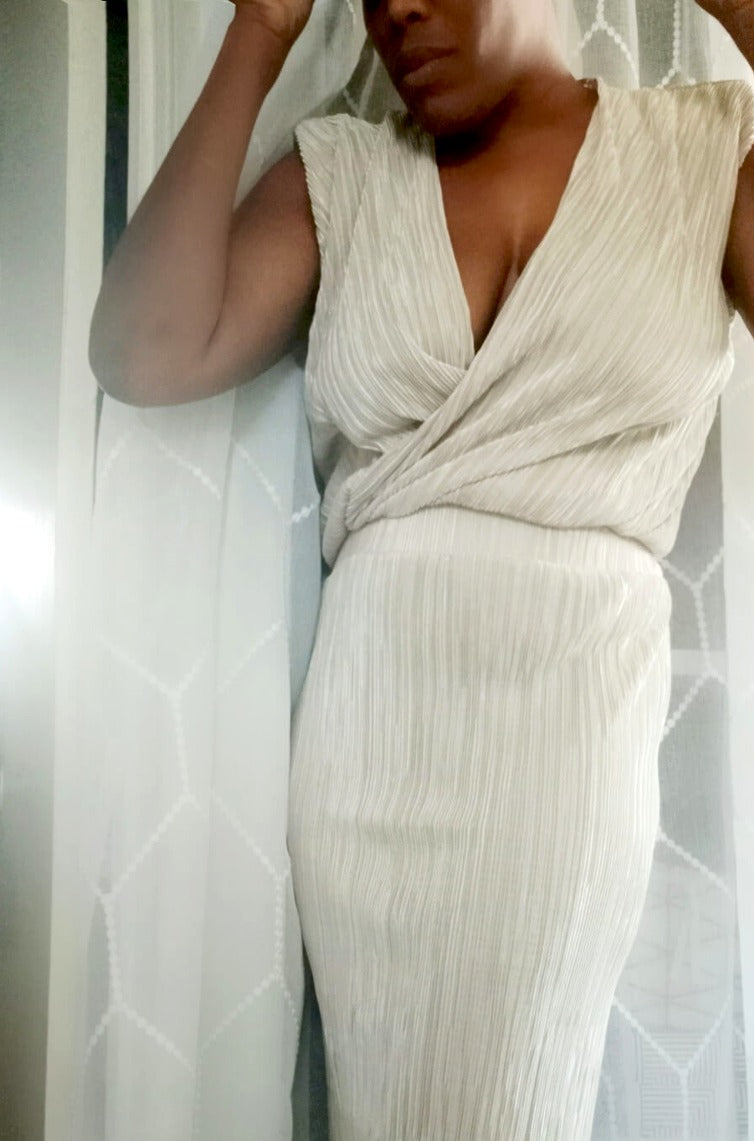 a woman in a white dress is talking on a cell phone
