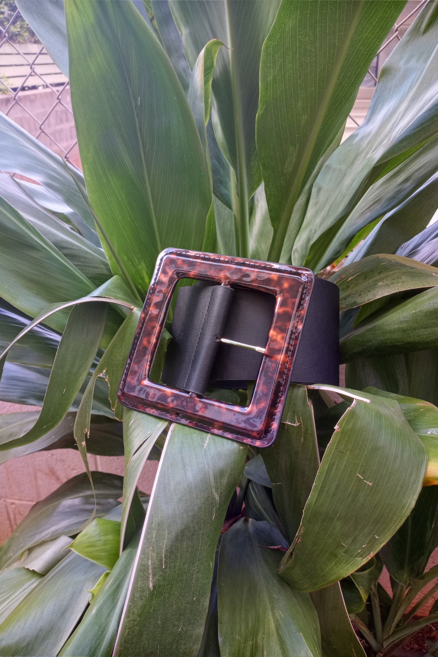 a pink piece of luggage sitting on top of a plant 