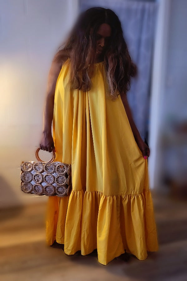 a woman in a yellow dress holding a cell phone