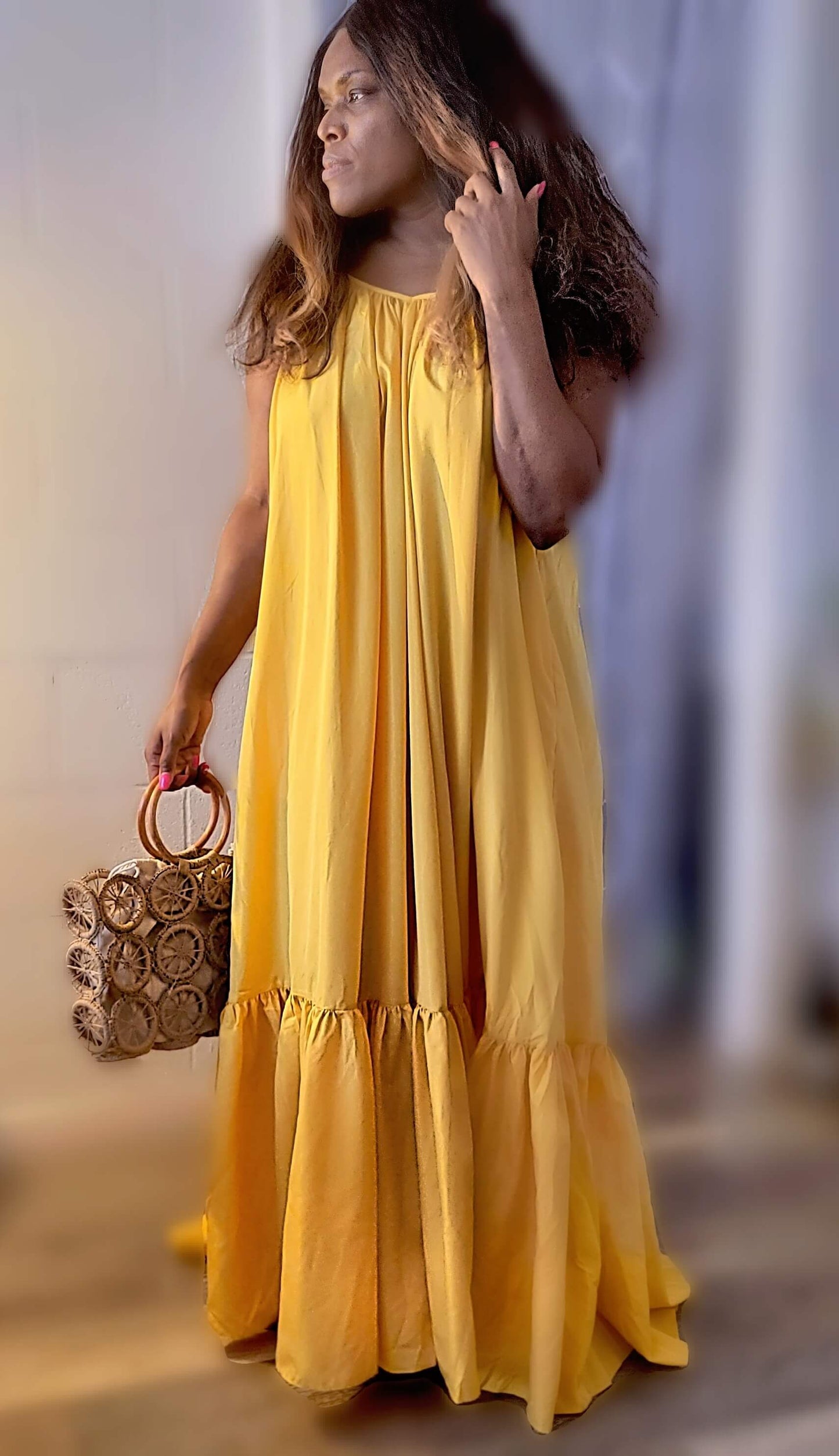 a woman in a yellow dress standing on a street 