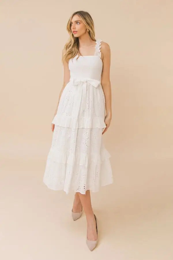 a woman in a white dress is holding a purse
