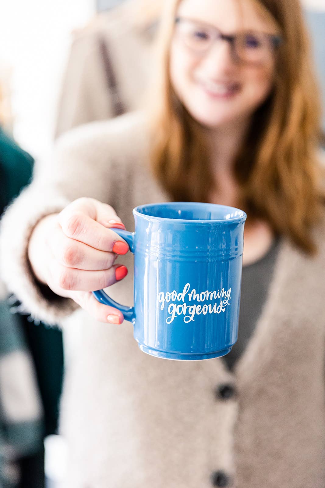 a woman holding a cup and a coffee cup