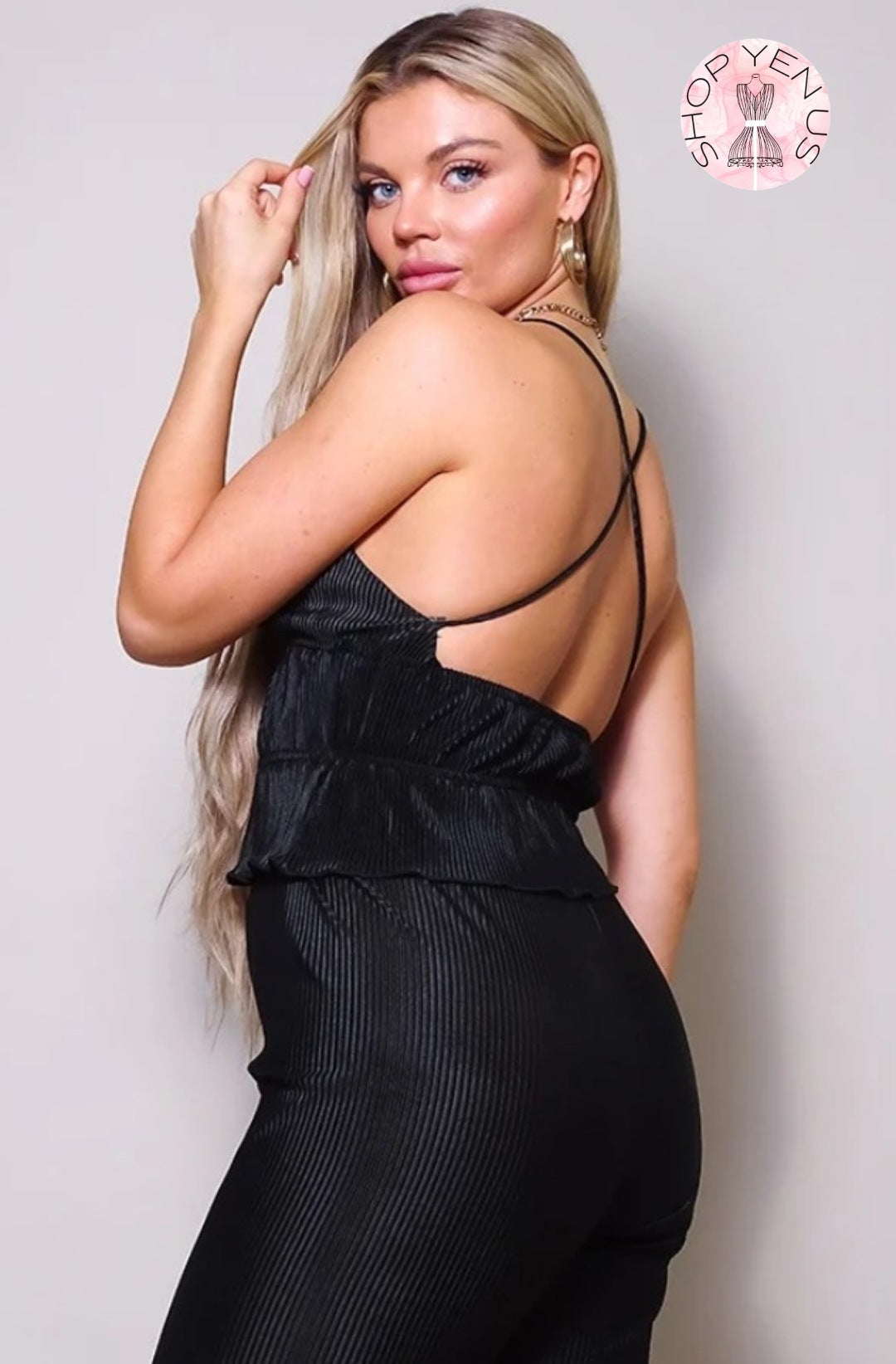 a woman in a black dress talking on a cell phone