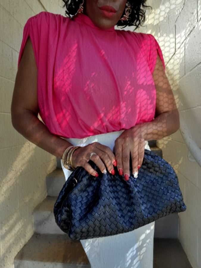 a woman in a pink dress holding a bag