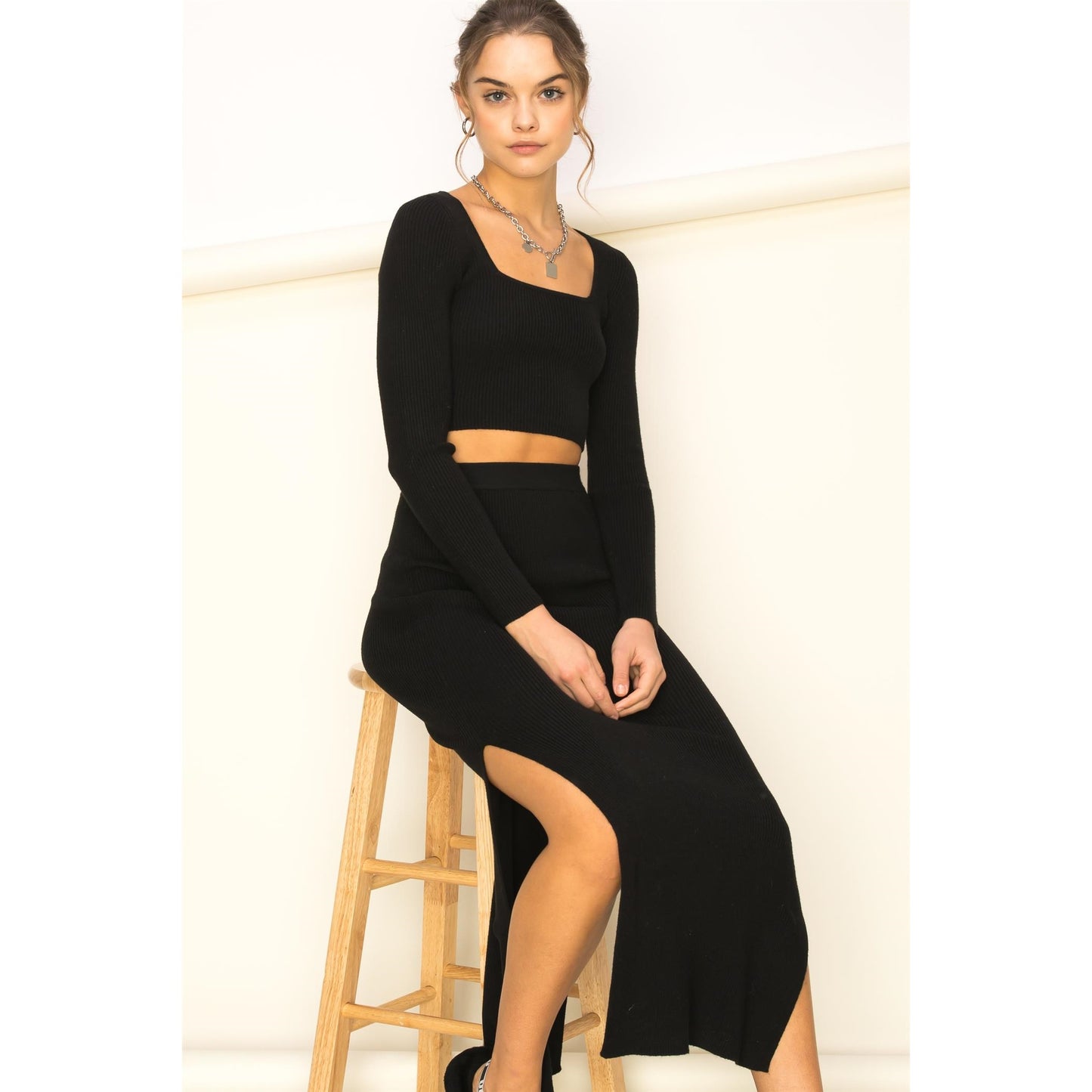 a woman in a black dress sitting on a bench