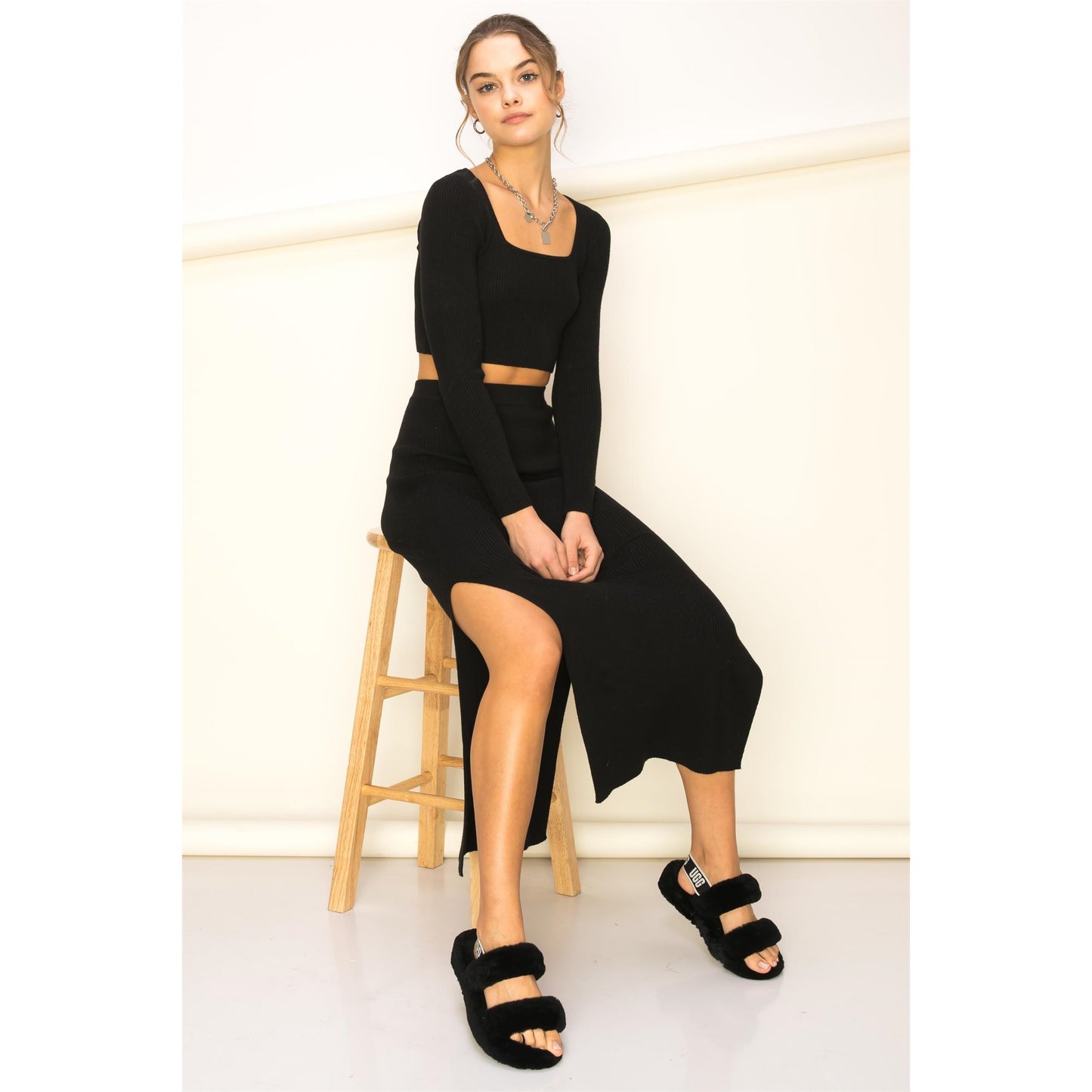 a woman is sitting on a bench with her legs crossed
