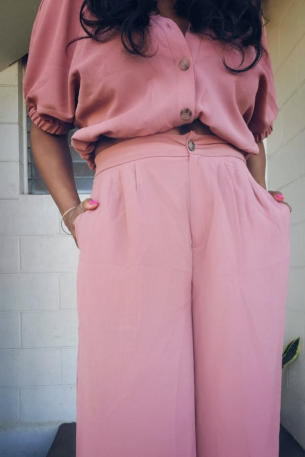 a woman in a pink dress holding a pink cell phone 