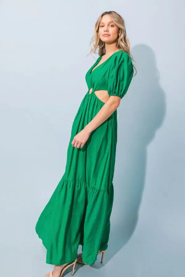a woman in a green dress holding a green bag 